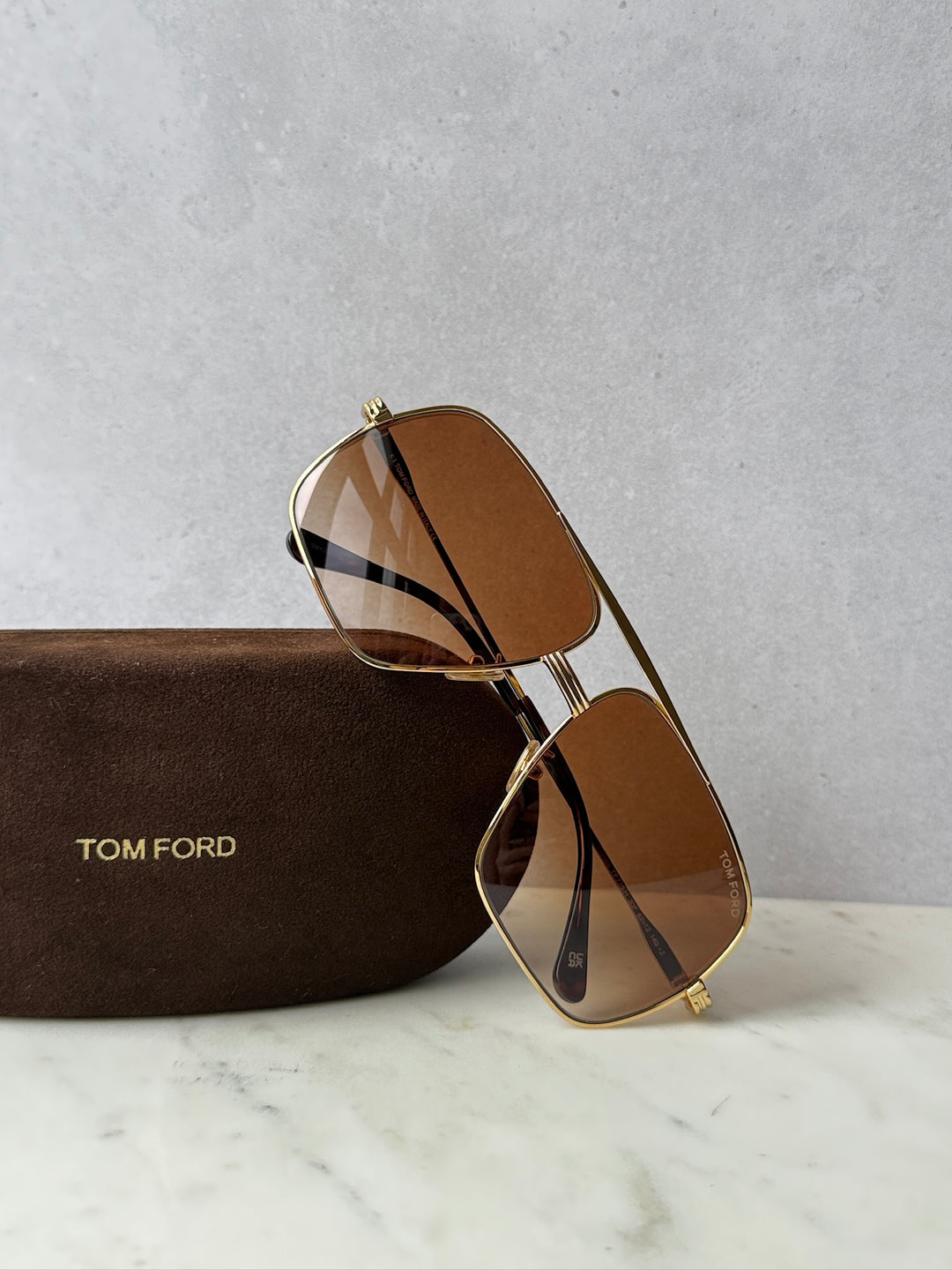 Gold-tone aviator sunglasses with brown gradient lenses, angled view