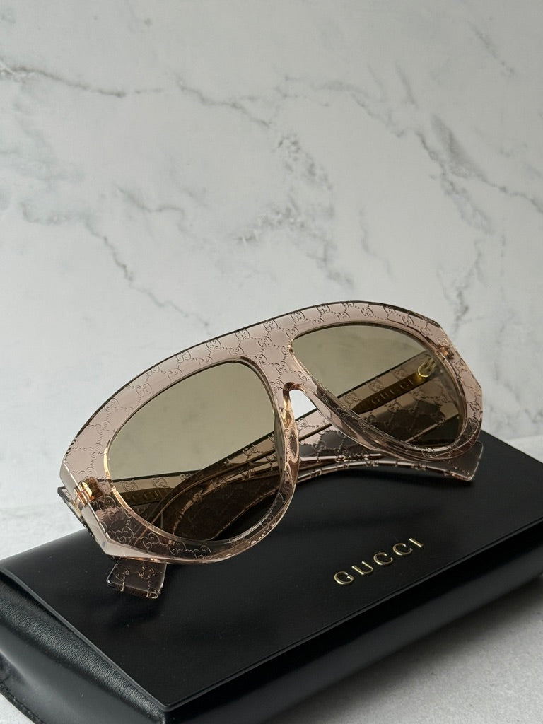 Beige GG-logo aviator sunglasses on black case, smoky lenses