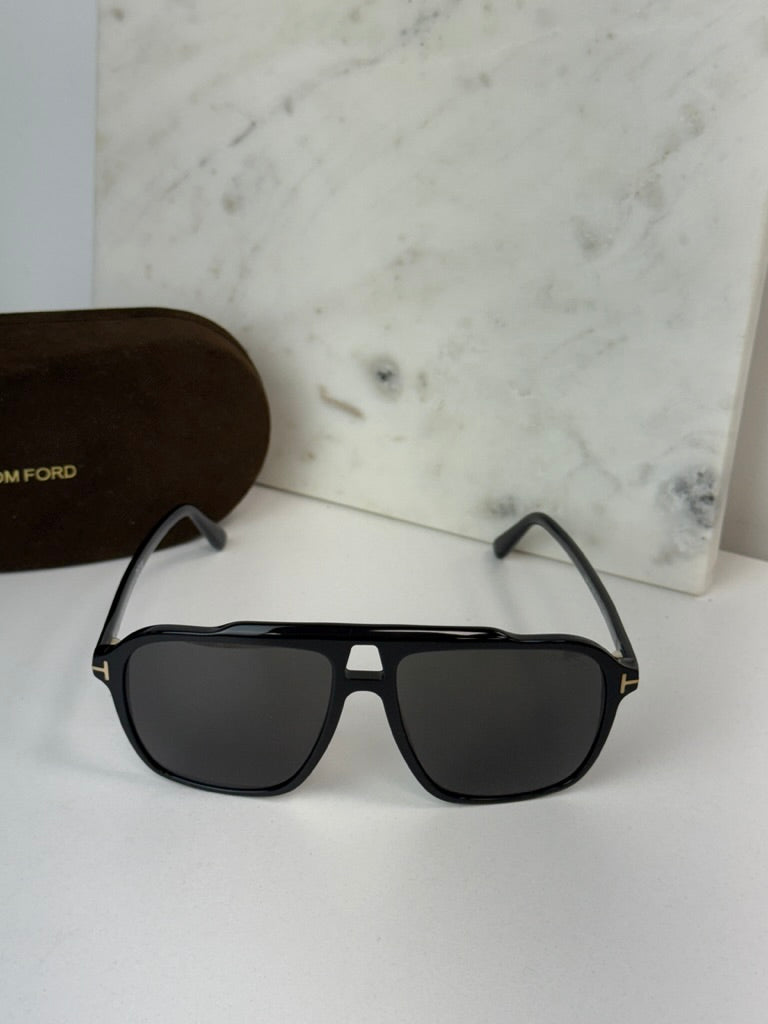 Black Tom Ford sunglasses with dark lenses and squared rectangular shape.