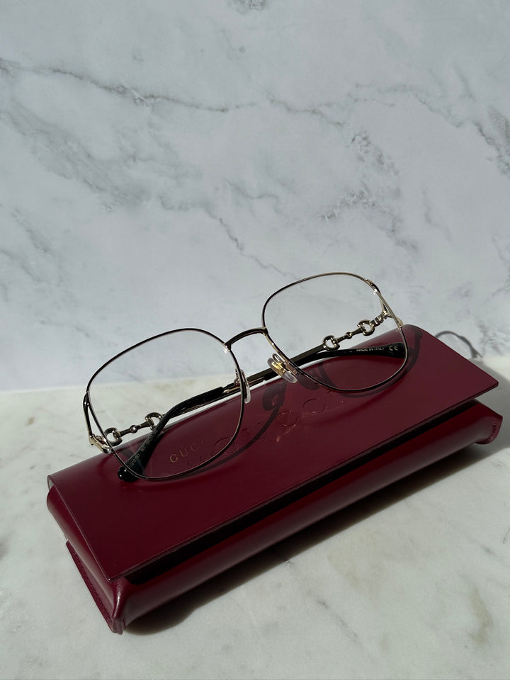 Gold oversized horsebit eyeglass frames with dark lenses and gold metal rims