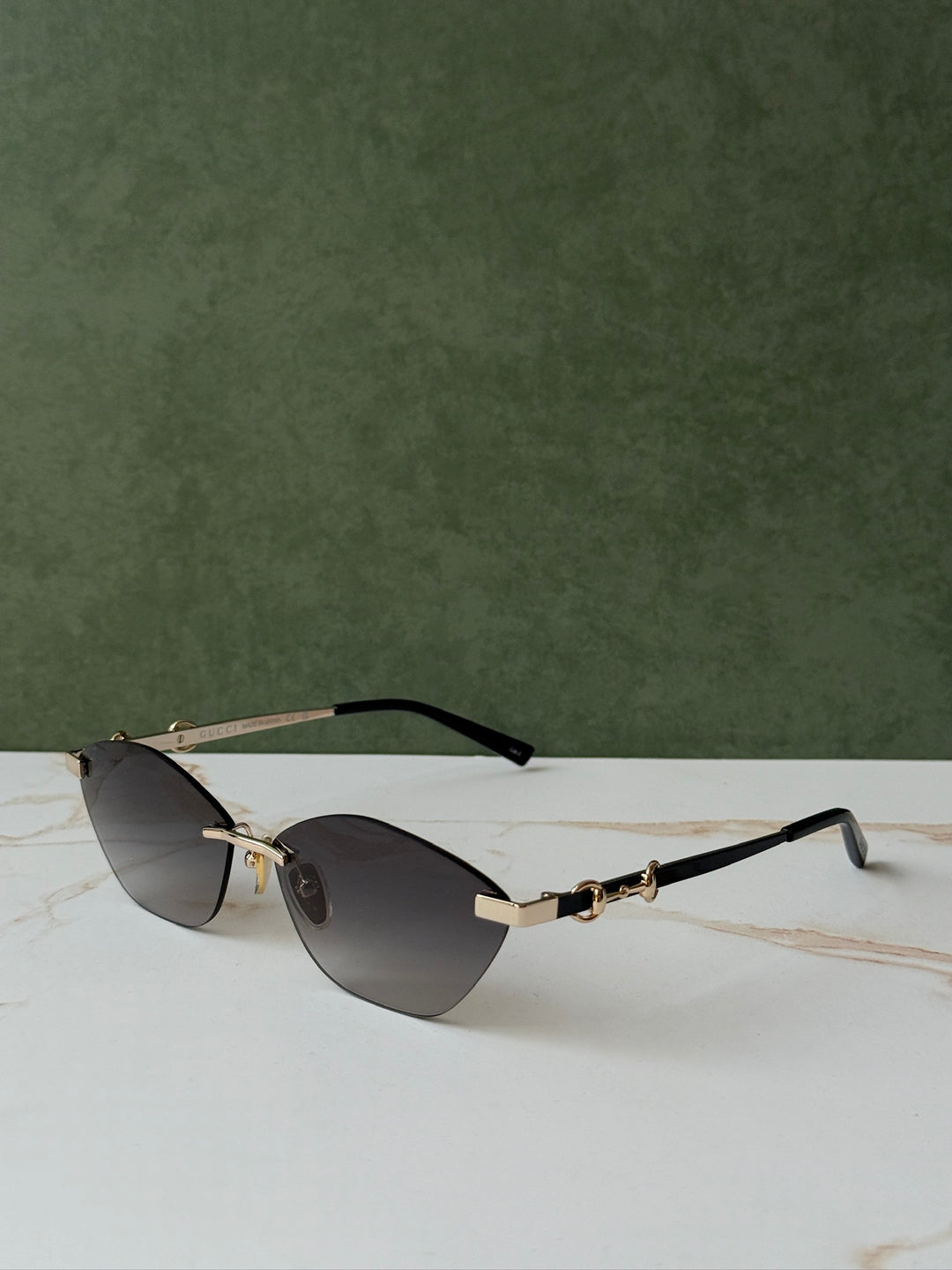 Gucci side view gold cat-eye sunglasses with black temple tips, horsebit bridge, dark lenses