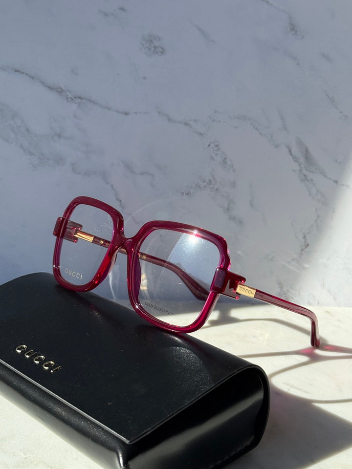 Pink red oversized square eyeglasses with clear lenses and temple brand on case