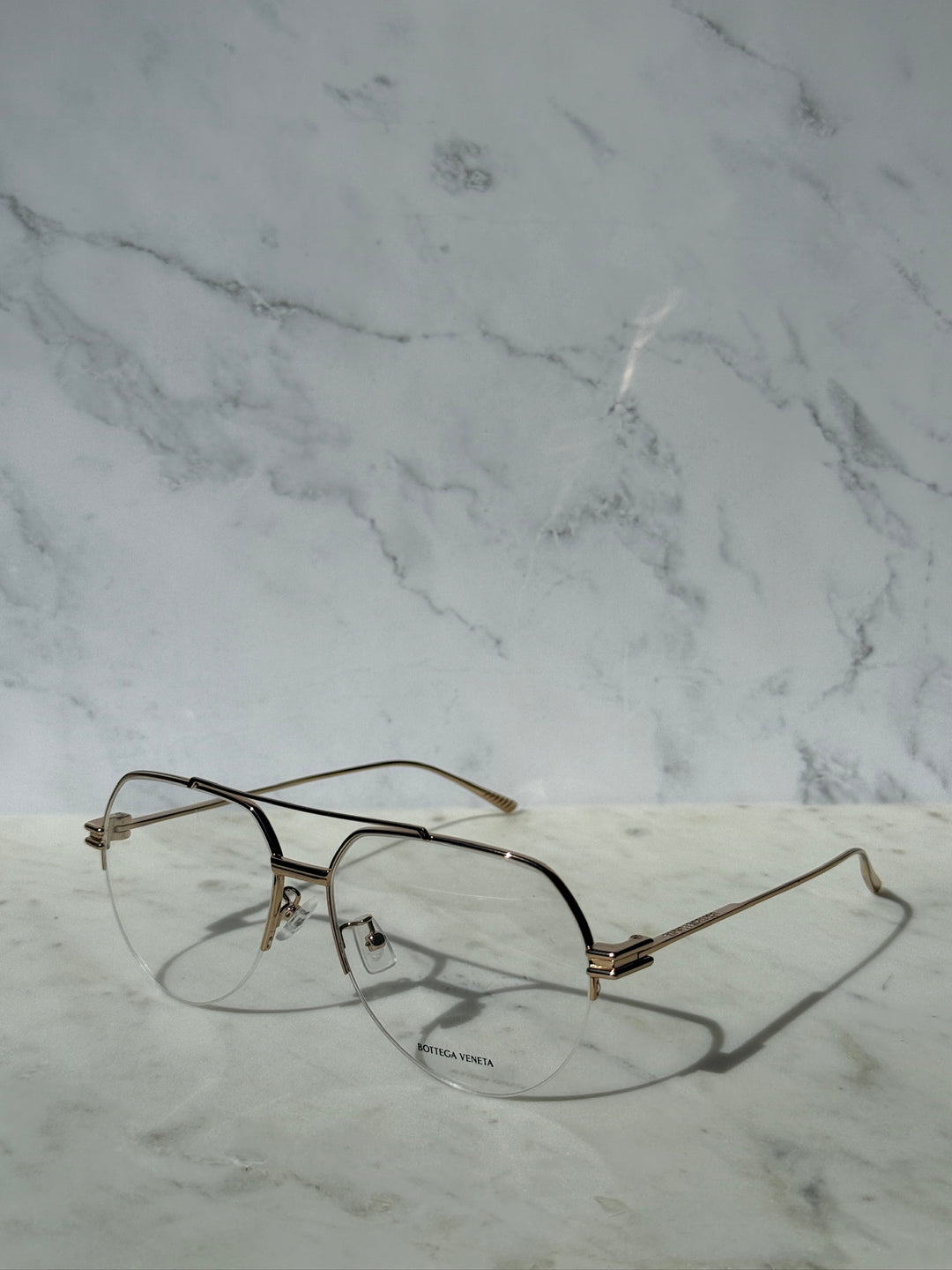 Gold metal aviator eyeglass frames with clear lenses, side view