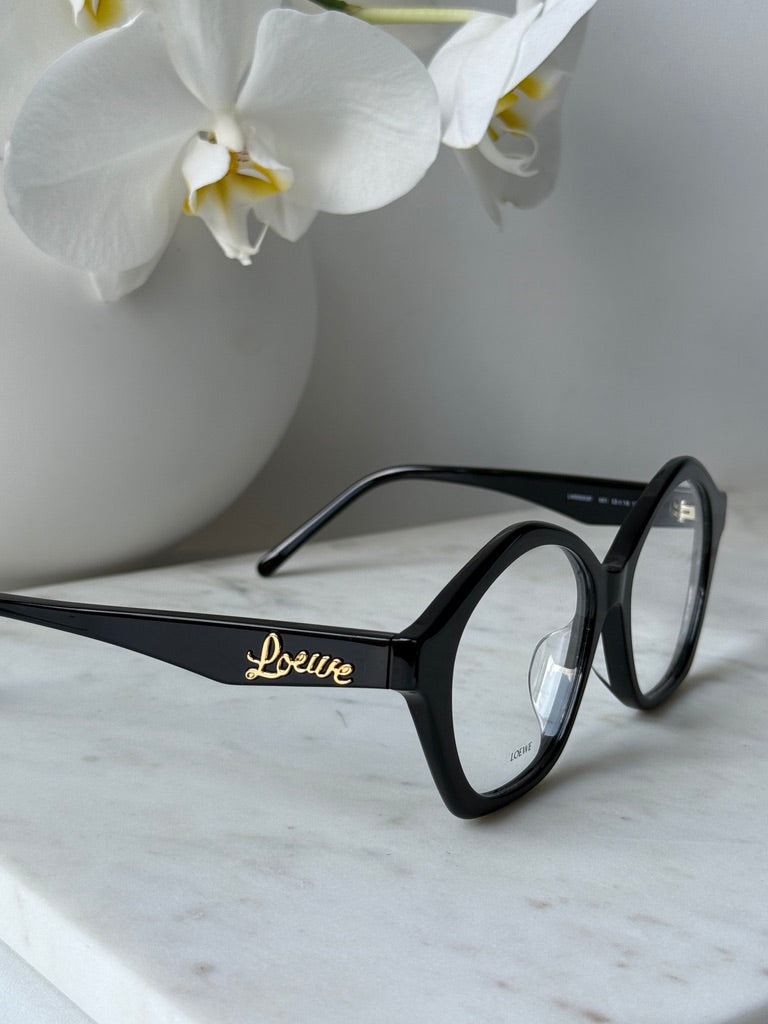 Black curvy eyeglass frames with gold Loewe logo on temple and curved bridge
