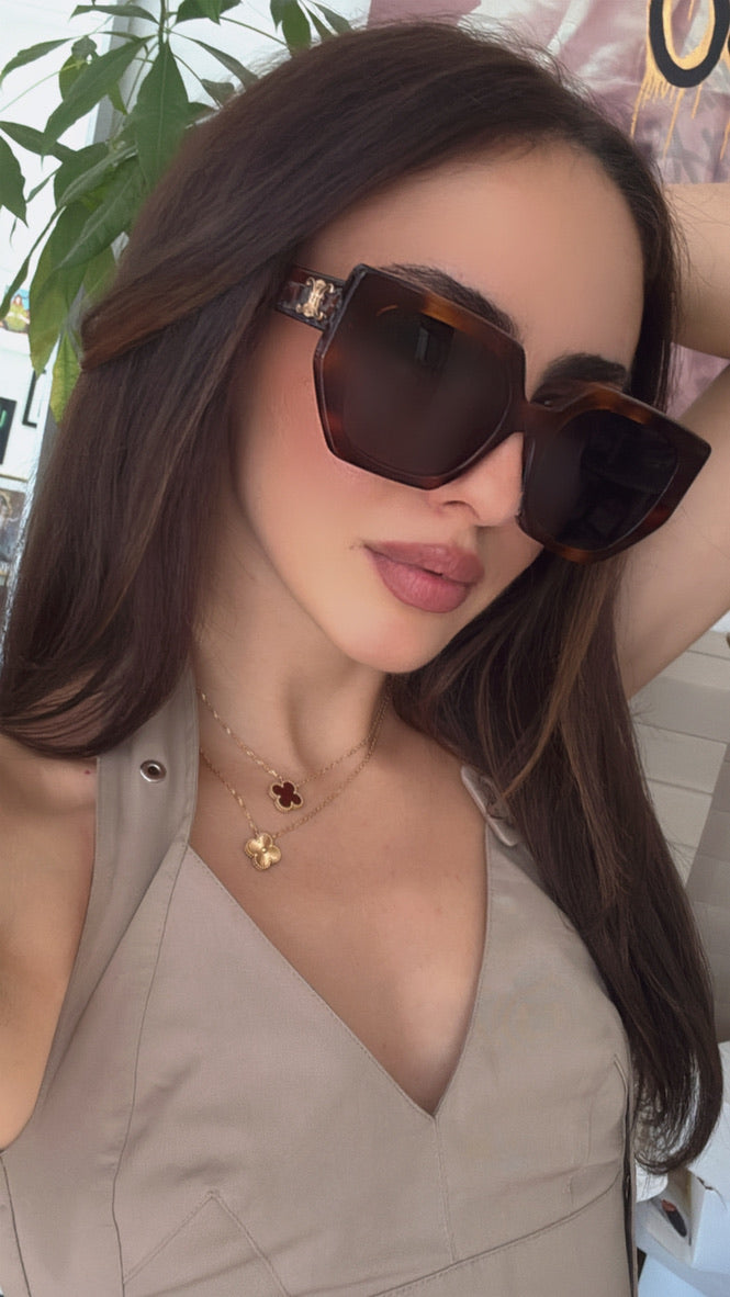 Square cat-eye sunglasses with brown tortoise frame and dark lenses, worn on face