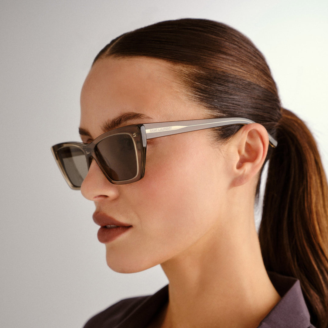 Saint Laurent cat-eye sunglasses on model, transparent brown frames, gray lenses
