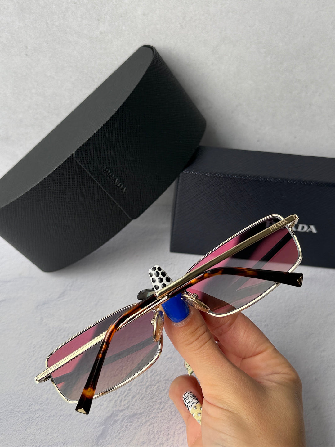 Gold metal sunglasses with gray tinted lenses and multicolor striped temple, PRADA case