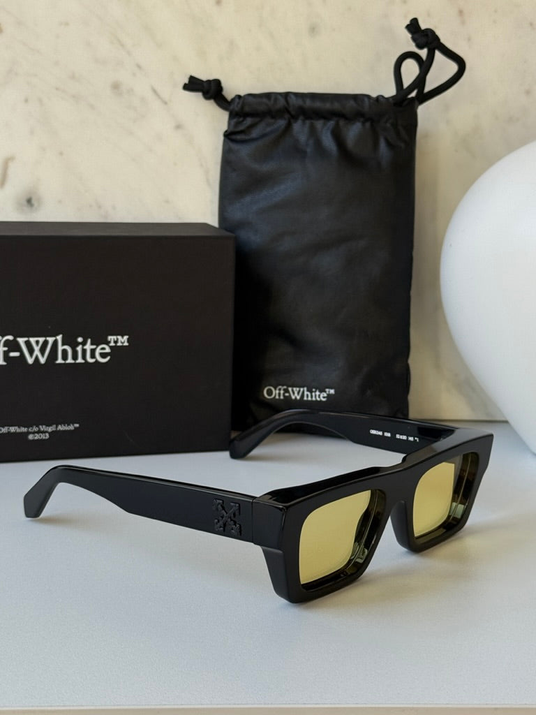 Black sunglasses with yellow lenses, side view with box and pouch