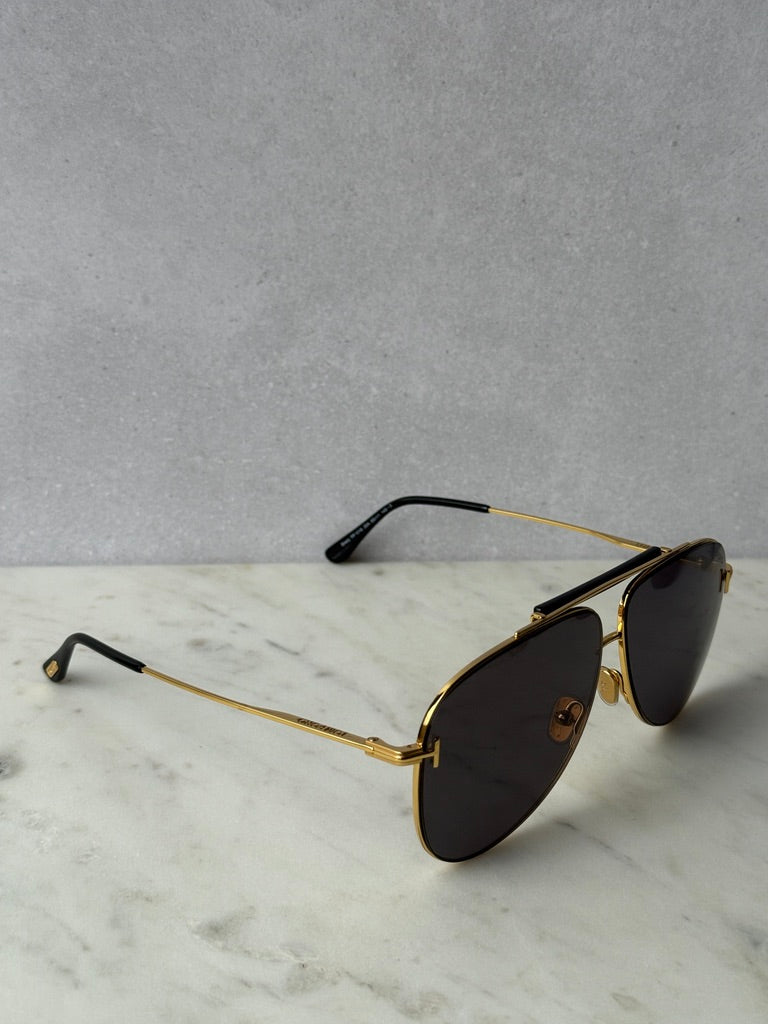 Gold aviator sunglasses angled view with dark lenses and black temples