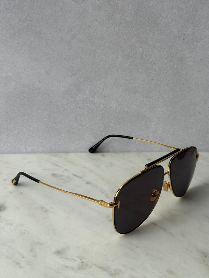 Gold aviator sunglasses angled view with dark lenses and black temples