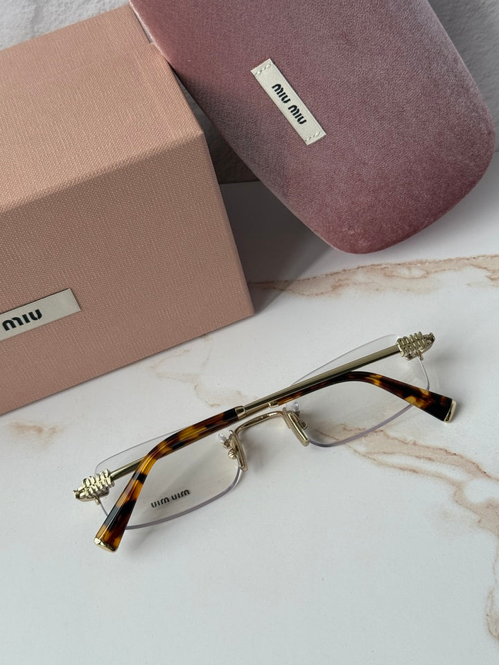 Miu Miu rimless eyeglass frames with gold arms and tortoise acetate temple tips