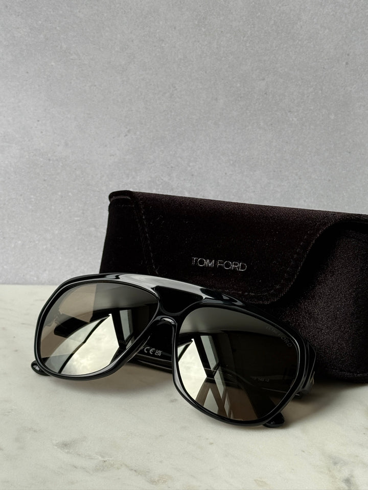 Black aviator sunglasses with mirrored lenses, TOM FORD logo case behind