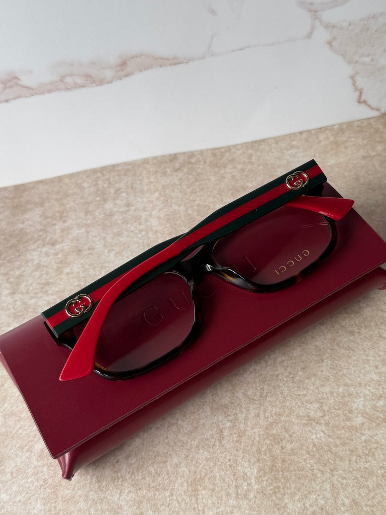 Black/red eyeglass frames with green stripe temple and Gucci logo