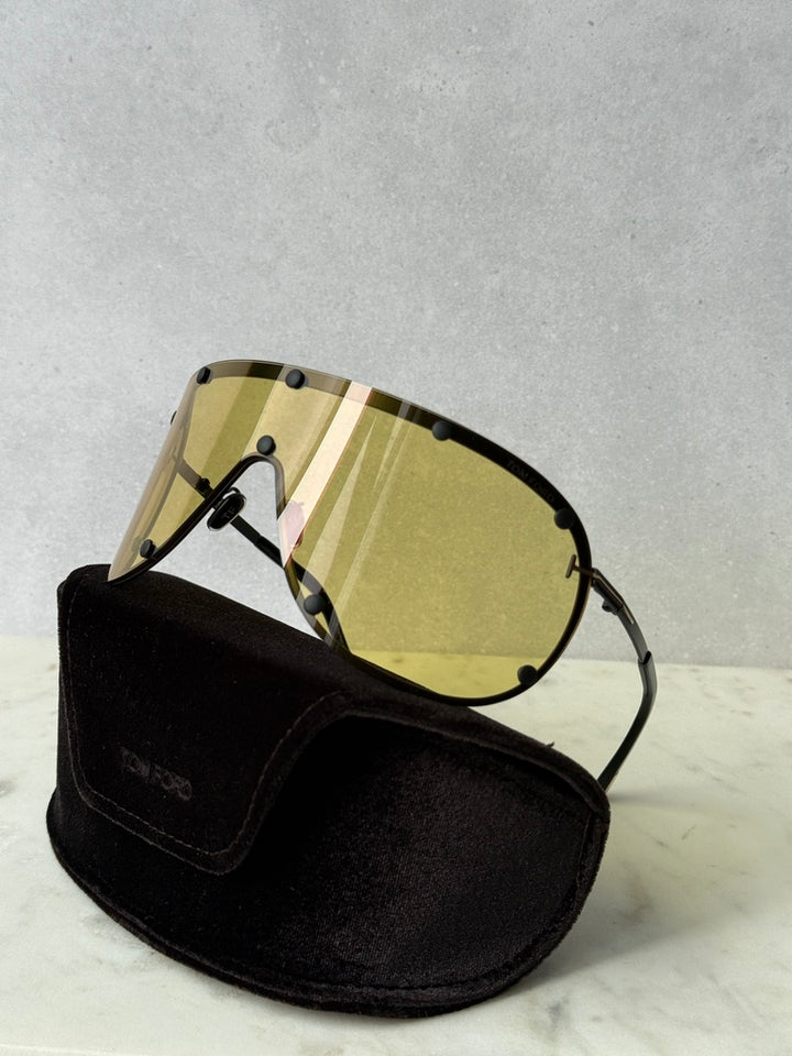 Yellow striped mask sunglasses, black frame and studs, resting on black pouch