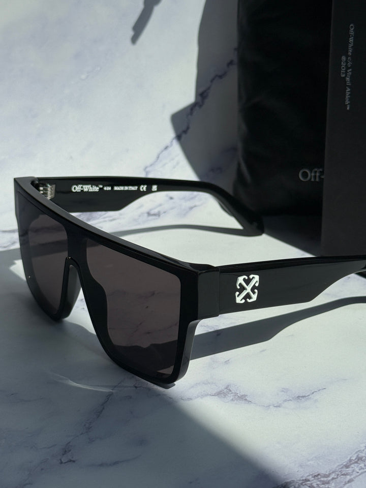 Black square sunglasses with dark tinted lenses and temple logo