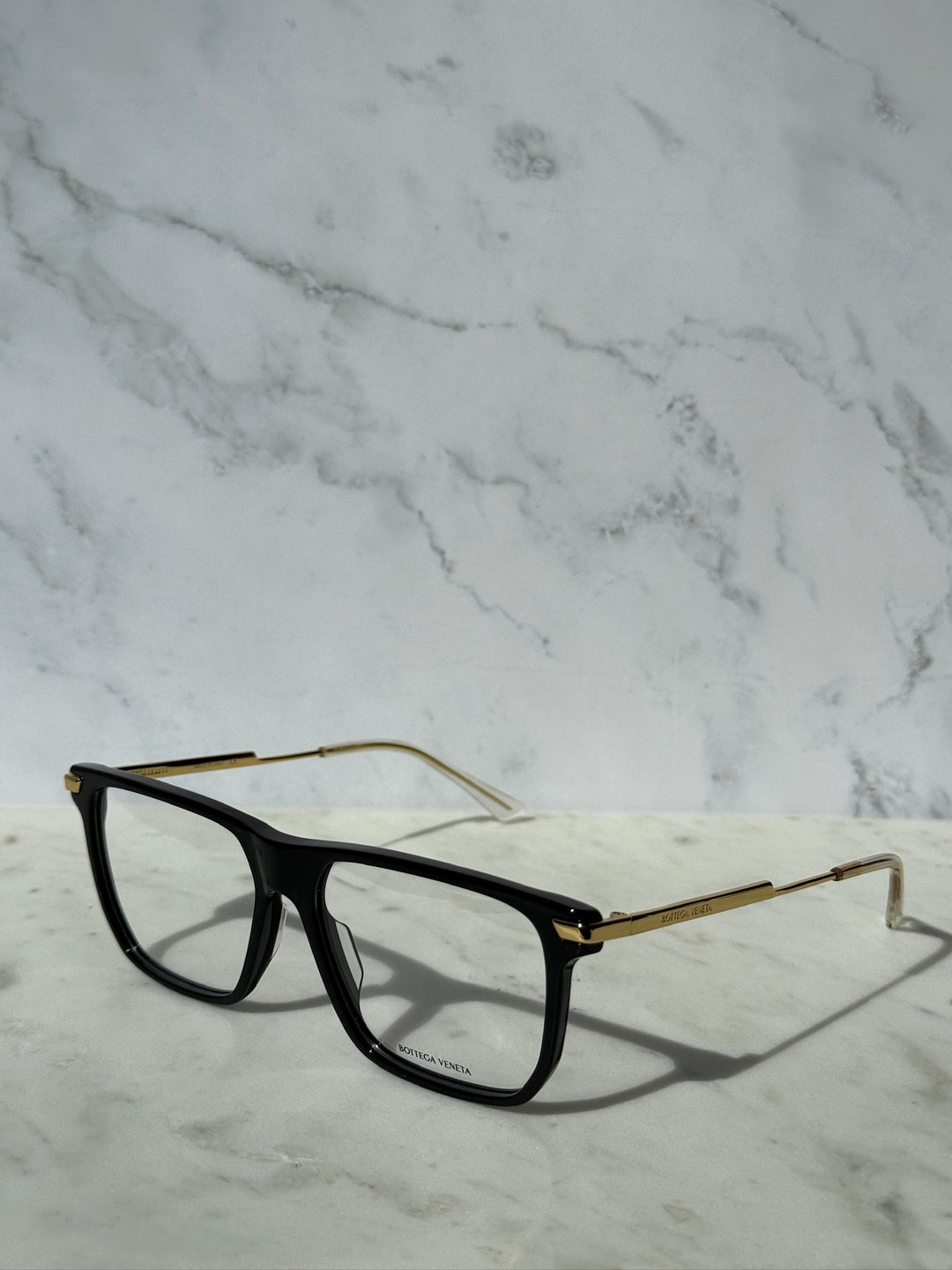 Black rectangular eyeglass frames with thin gold-tone temples and metal hinges.