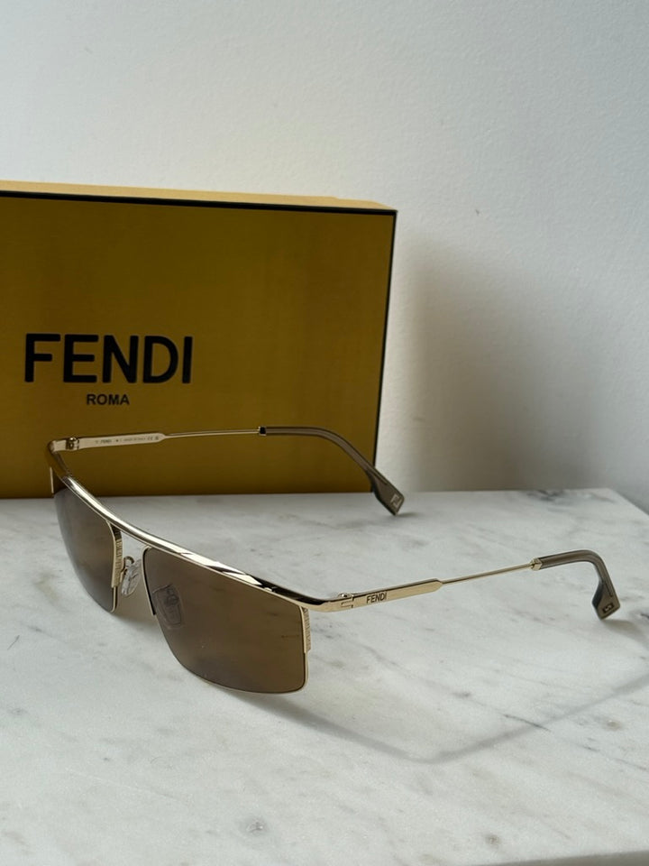 Fendi metal sunglasses with gold frame and brown lenses, angled front view