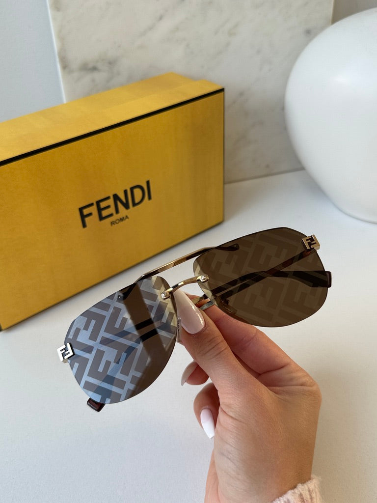 Gold aviator sunglasses close-up with brown FF-pattern lenses and Fendi FF temple logo