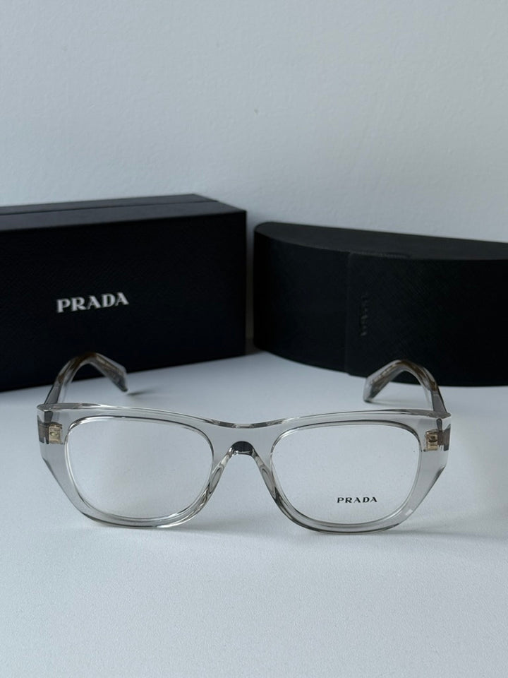 Clear square eyeglass frames with gold-tone PRADA branding on temples