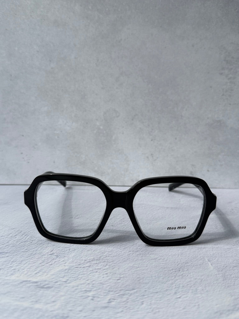 Black square eyeglass frames with clear lenses and gold brand on temple