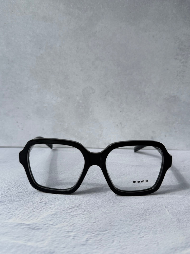 Black square eyeglass frames with clear lenses and gold brand on temple