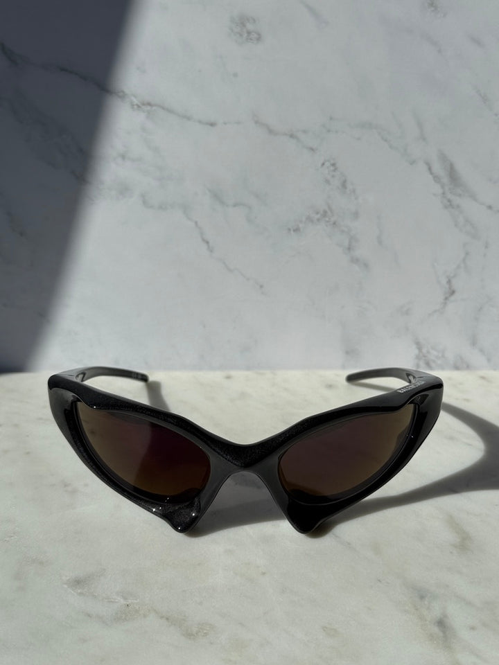 Black runner mask sunglasses with dark mirrored lenses and pointed cat-eye corners