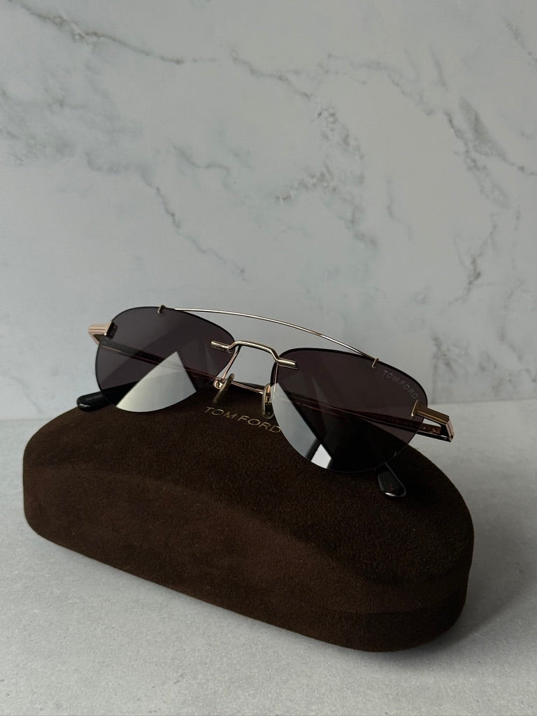 Rose gold aviator sunglasses with dark lenses and metal bridge, angled view