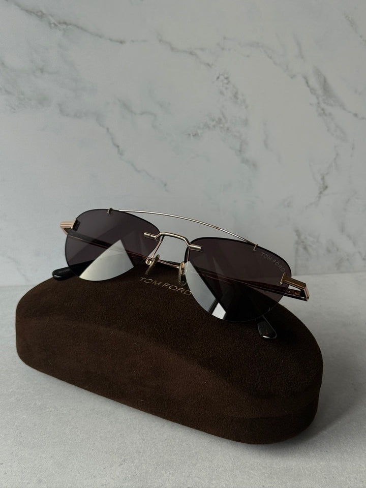 Rose gold aviator sunglasses with dark lenses and metal bridge, angled view