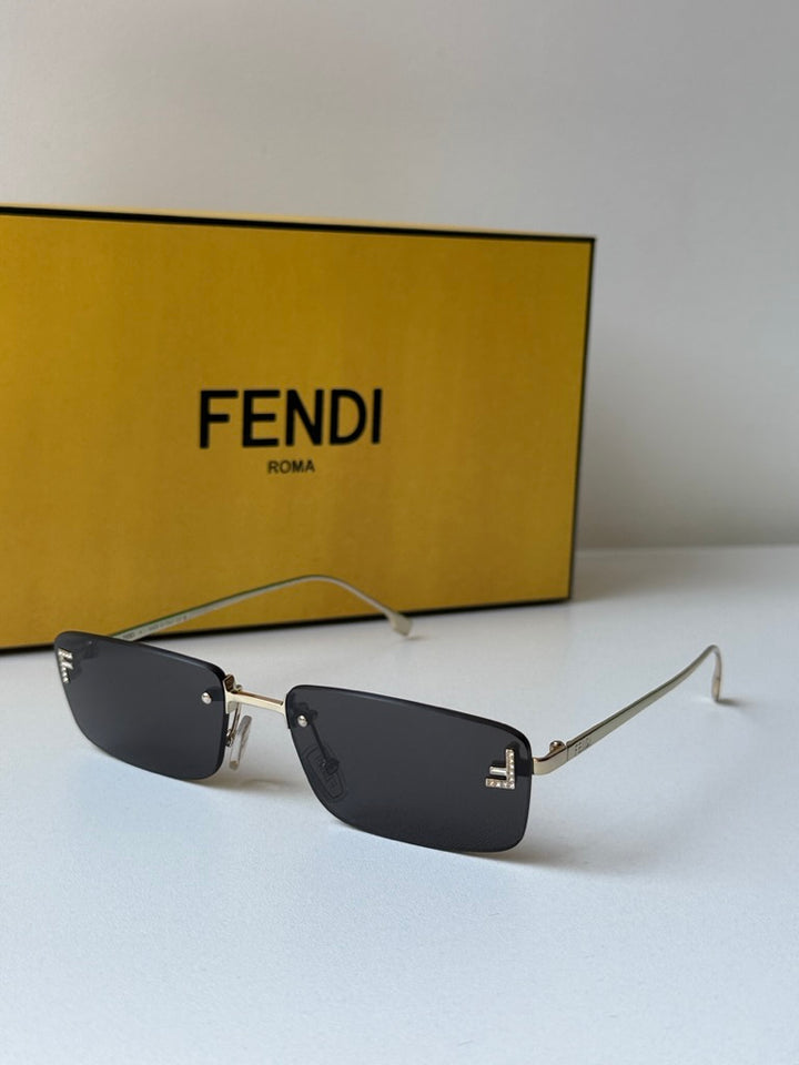Fendi rimless sunglasses with dark lenses and gold frame, black logo detail