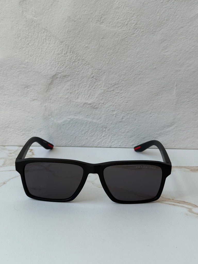 Black polarized square sunglasses with dark lenses and red accents on both temples