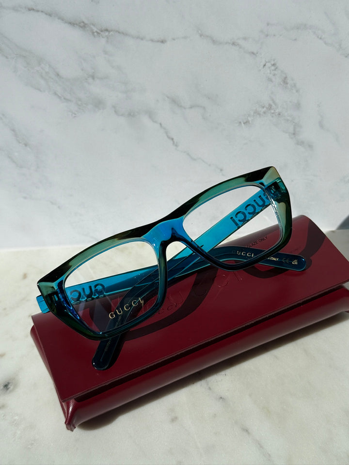 Blue Gucci eyeglasses frames, rectangular clear lenses, dark temple arms.