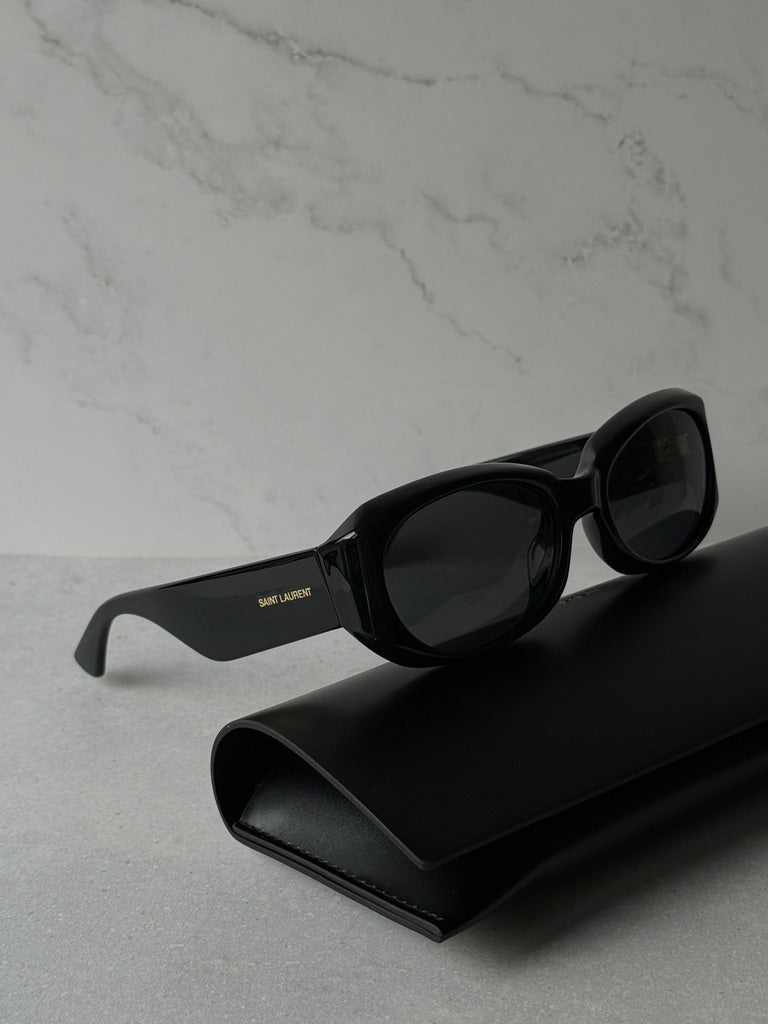 Black sunglasses with dark lenses, angled side view, logo on arm