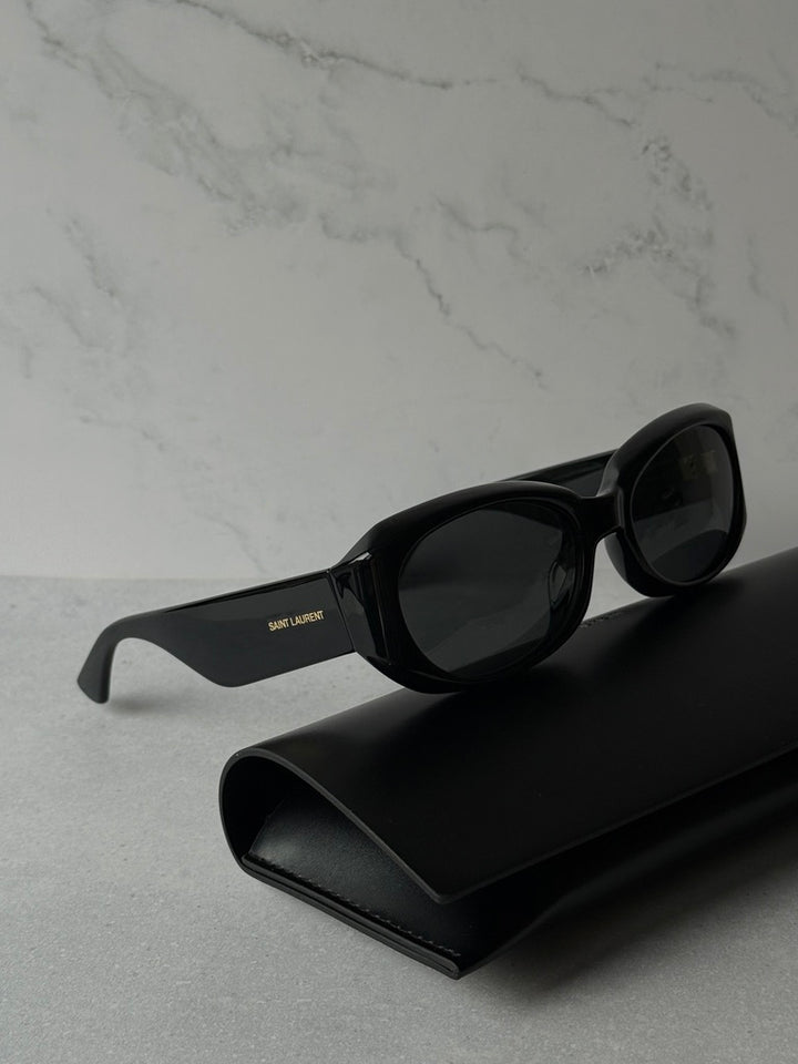 Black sunglasses with dark lenses, angled side view, logo on arm