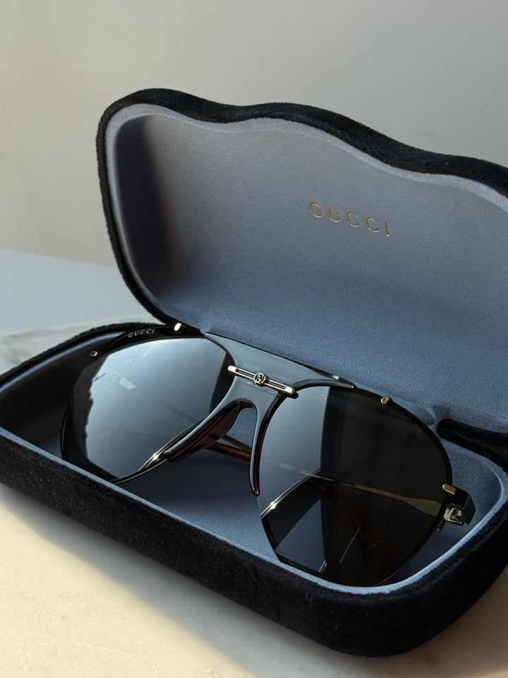 Gucci aviator logo sunglasses in open dark case, dark lenses and gold-tone bridge