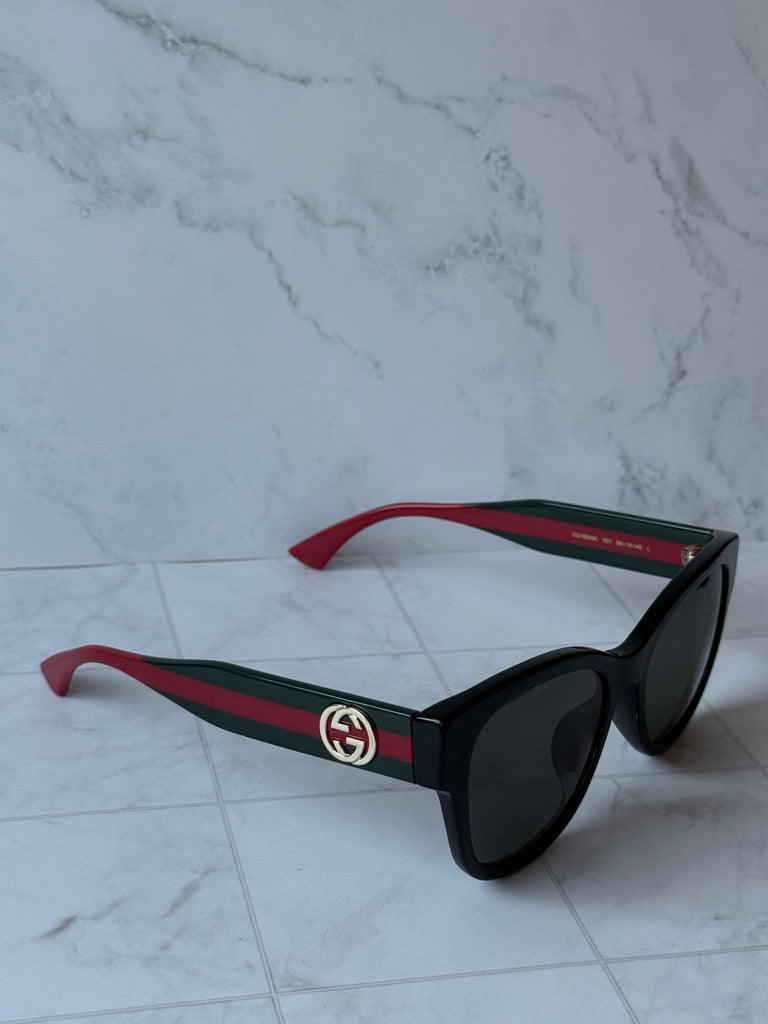Gucci black temple sunglasses with red-green stripes and dark lenses