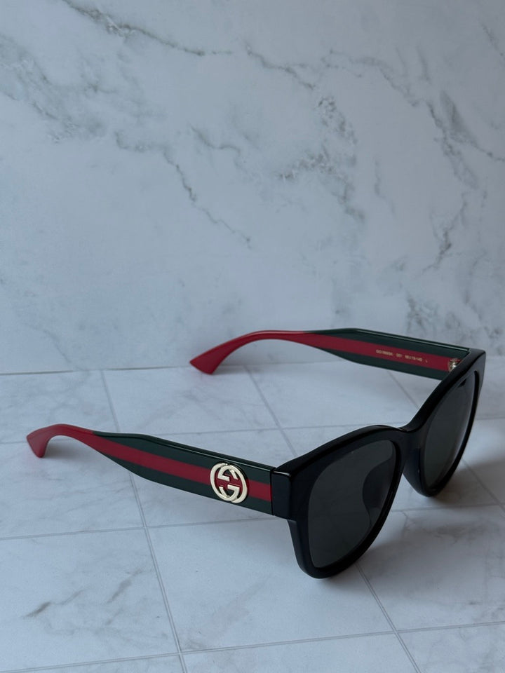 Gucci black temple sunglasses with red-green stripes and dark lenses
