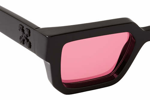 Black sunglasses close-up with pink tinted lens and engraved temple