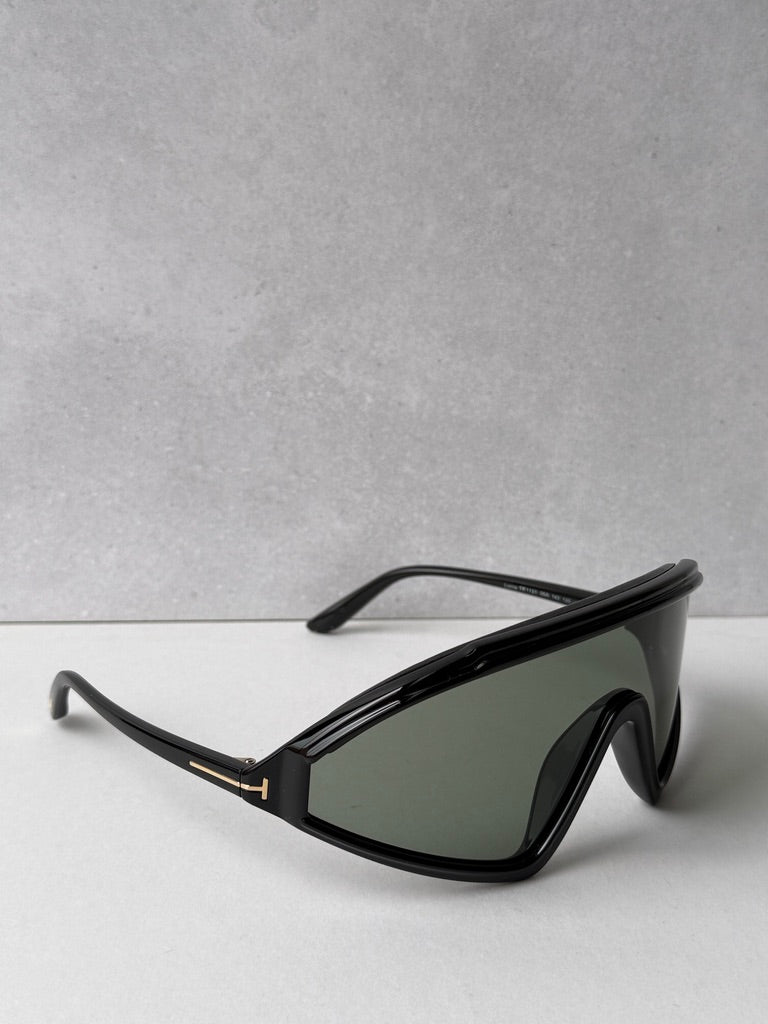Black sunglasses with dark green lenses and gold-accent hinge detail, side view
