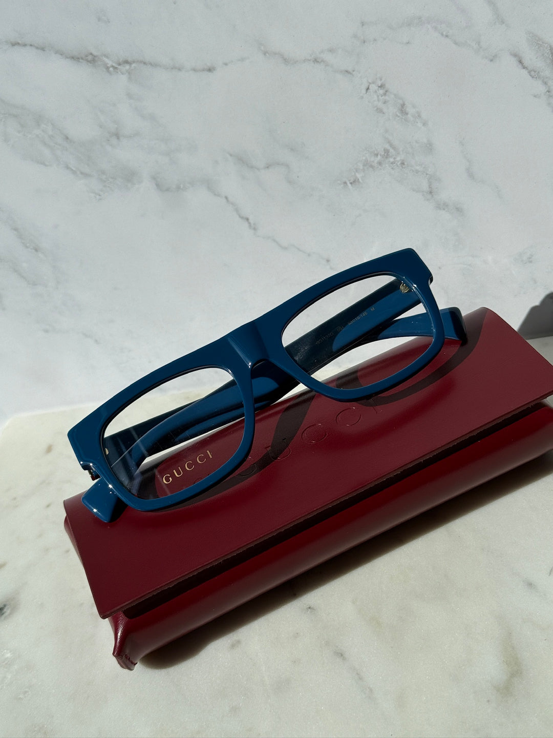 Gucci blue rectangular eyeglass frames with dark temples, shown in case