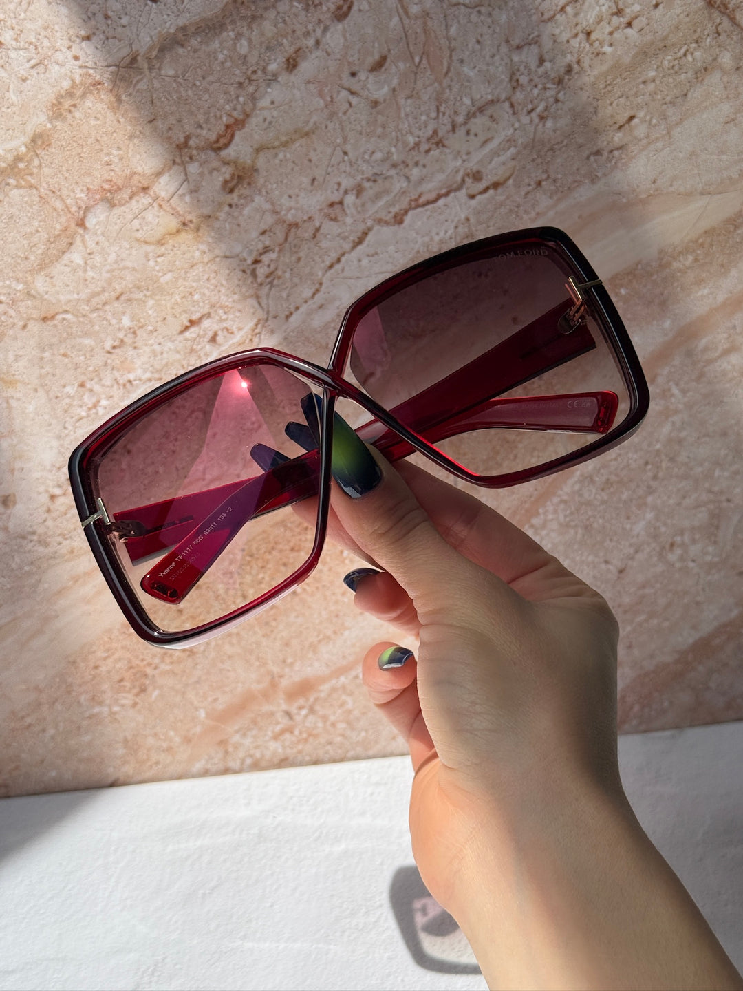 Burgundy square sunglasses close-up with tinted gradient lenses and gold-tone hinge
