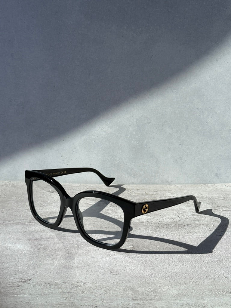 Black square eyeglass frames with dark temple logo detail
