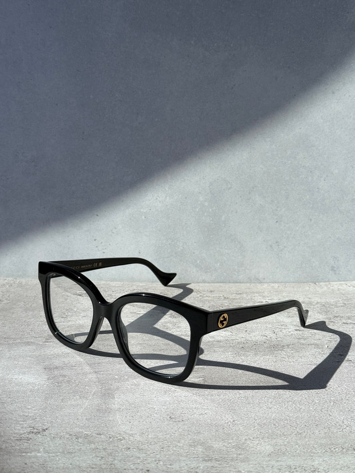Black square eyeglass frames with dark temple logo detail