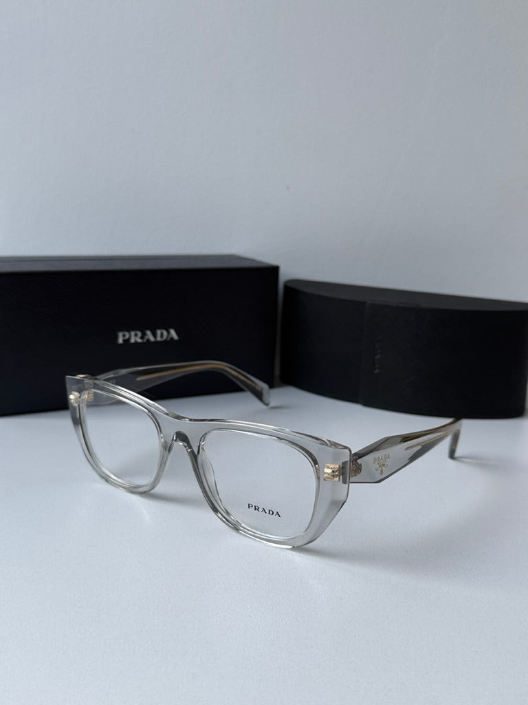 Clear square eyeglass frames with gold-tone PRADA logo on temples