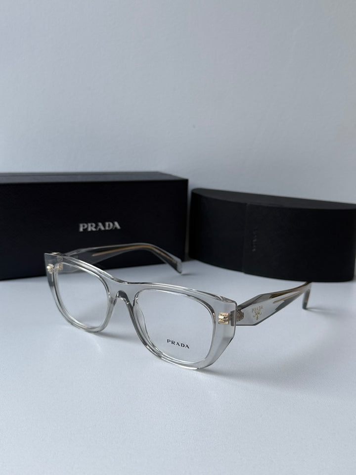 Clear square eyeglass frames with gold-tone PRADA logo on temples