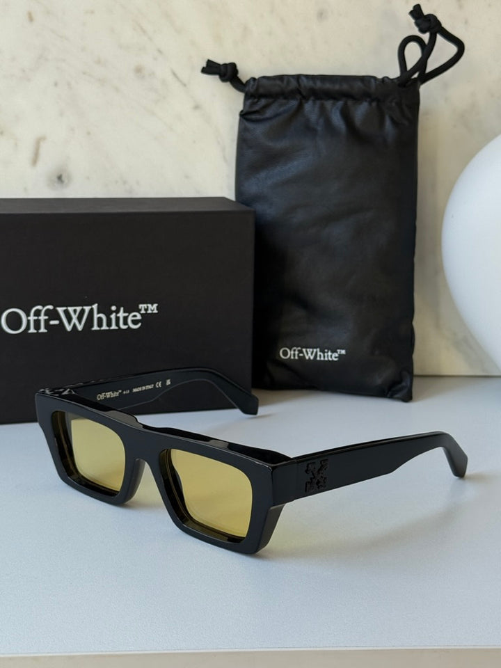 Black sunglasses with yellow lenses, shown with storage pouch and box