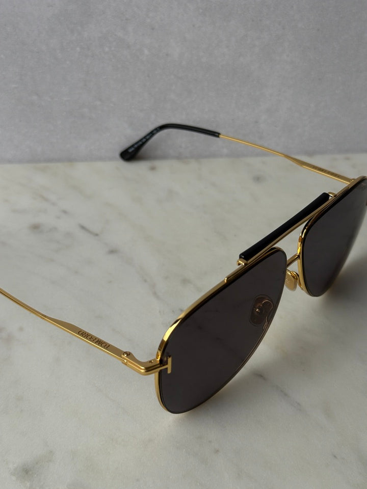 Gold aviator sunglasses angled view showing temple and dark lenses