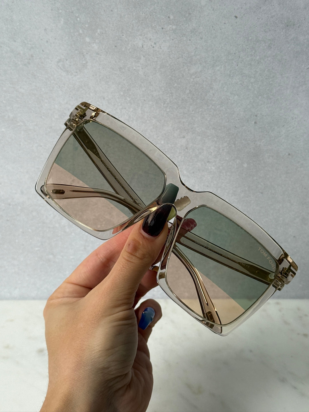 Square transparent mirror sunglasses with gold-tone frame, angled front view