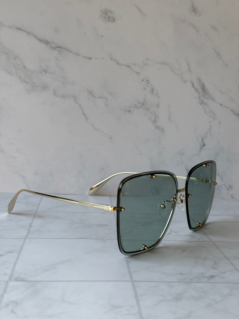 Oversized square sunglasses in dark green with gold metal frame and temples