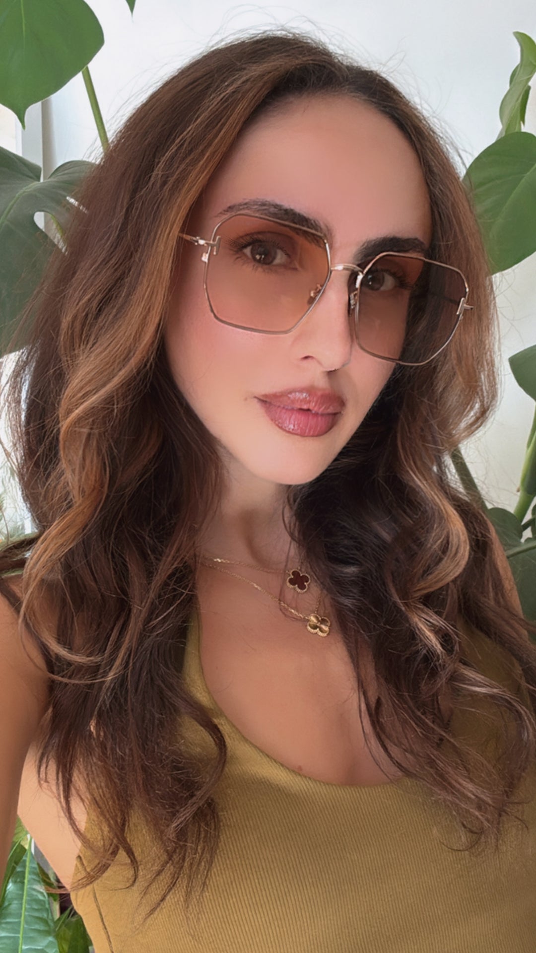 Tom Ford square sunglasses on face, gold frame with tinted amber lenses