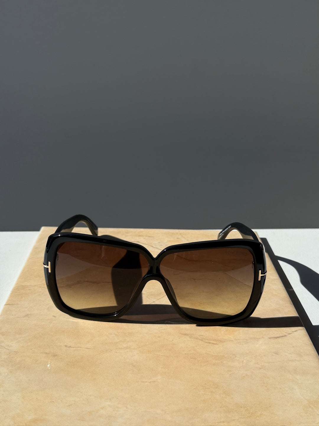 Black square sunglasses with brown-tinted lenses and curved arms